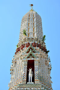 Low angle view of statue against building against sky