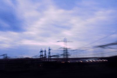 Silhouette electricity pylon against sky during sunset