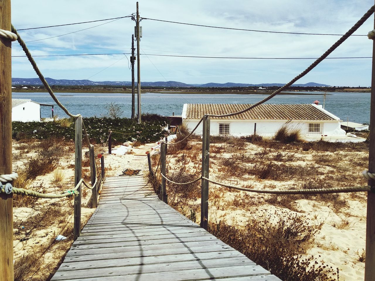 FOOTPATH LEADING TOWARDS SEA BY MOUNTAIN AGAINST SKY