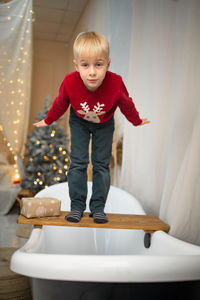 Portrait of cute girl sitting on slide at home