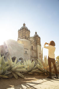 Man taking photo with an iphone of santo domingo church in oaxaca