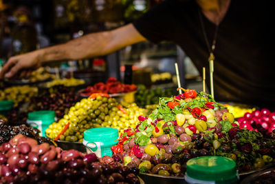 Midsection of vendor selling olives in market