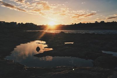 Heart shape on shore against sky during sunset