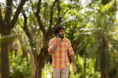 Young man at park on a beautiful sunny day with mobile phone.  working  leisure. green and nature 