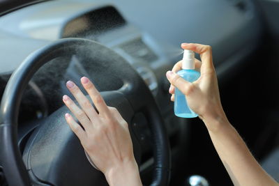 Hand of woman is spraying alcohol,disinfectant spray in car,safety,prevent infection of covid 19 