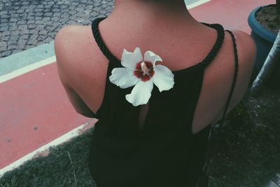 Midsection of woman wearing white flower on back