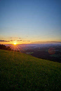 Scenic view of field against sky during sunset