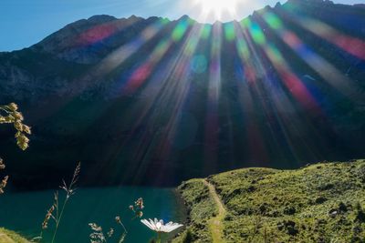 Lake against mountain on sunny day