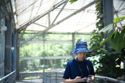 Man looking at camera while standing by plants