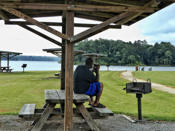 Man photographing on field by lake okhissa