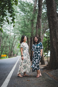 Full length of woman standing against trees