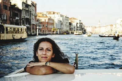 Portrait of smiling woman with boats in water