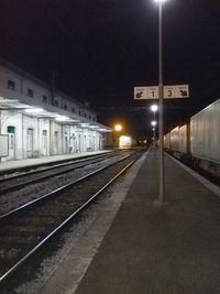 Train at railroad station platform against sky at night