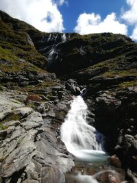 Scenic view of waterfall against sky