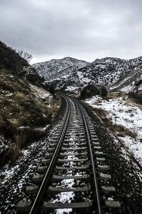 Railroad tracks against snow covered landscape