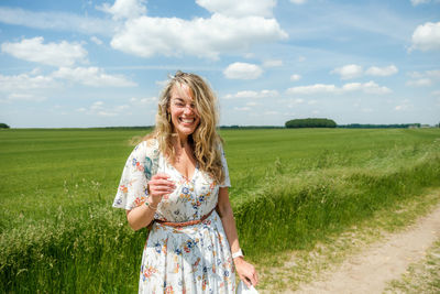 Happy woman on field against sky