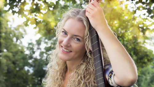 Portrait of smiling woman against trees