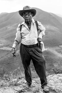 Full length portrait of man standing against mountains