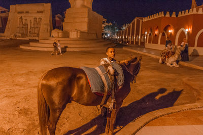 View of people riding horse at night