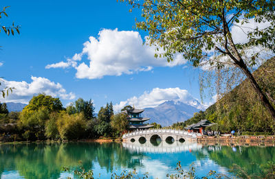 Arch bridge over lake against sky