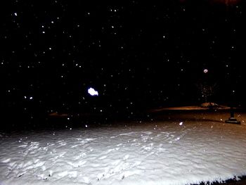 Scenic view of snow against sky at night