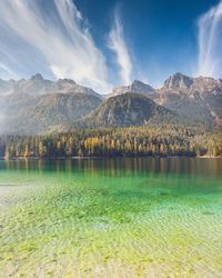 Scenic view of lake by mountains against sky