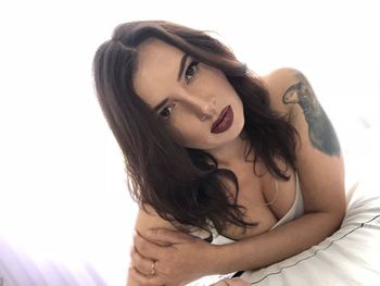 Portrait of sensuous woman with long hair lying down on bed