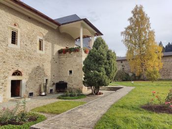 Footpath amidst houses and buildings against sky