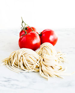 Close-up of cherry tomatoes on table against white background