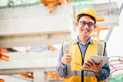 Portrait of smiling man holding mobile phone