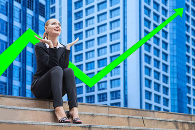 Full length of a smiling woman against building in city