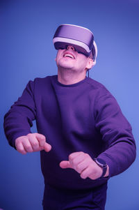 Man wearing hat standing against blue background