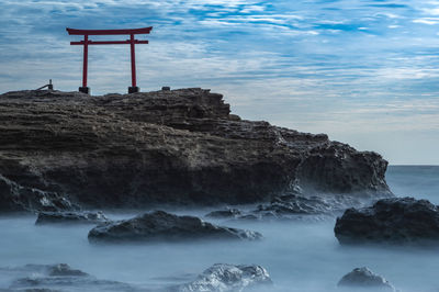 Scenic view of rocks on beach against sky