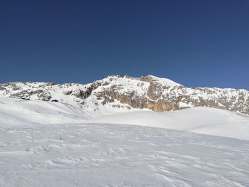 Snow covered mountain against blue sky