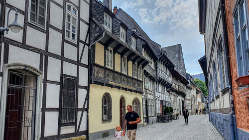 People walking on street amidst buildings in city