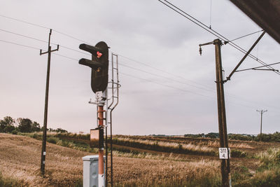 Electricity pylon on field against sky