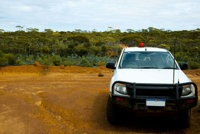 Car on road by land against sky