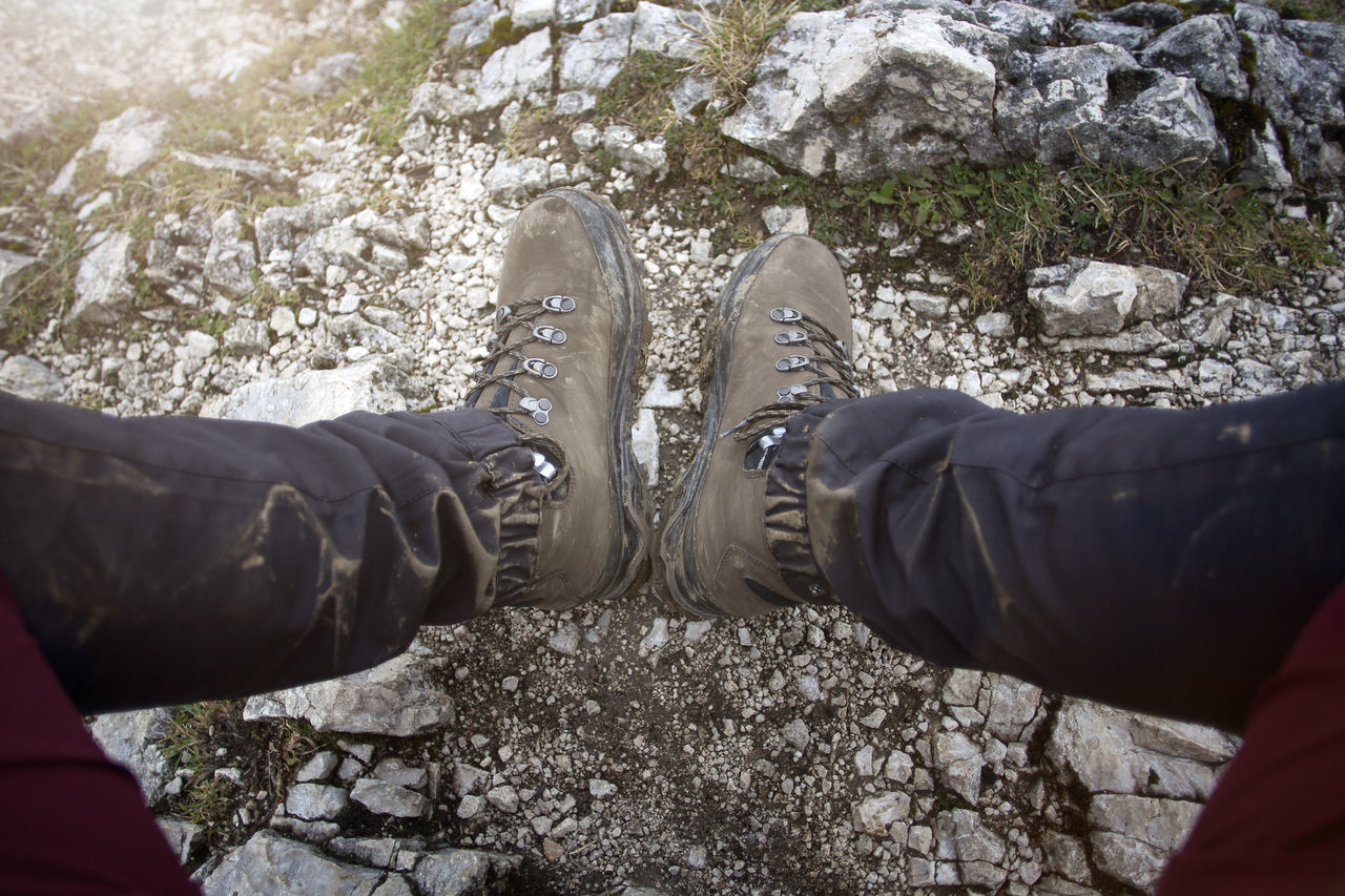 low section, personal perspective, human leg, shoe, lifestyles, nature, leisure activity, one person, day, spring, men, adult, outdoors, limb, footwear, rock, human limb, standing, high angle view, clothing, land, tree, winter, plant, human foot