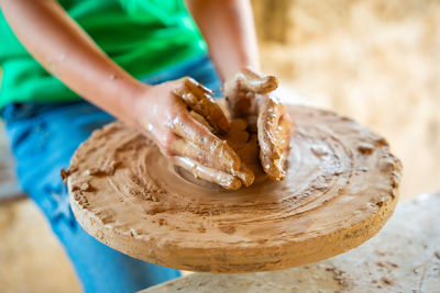 Midsection of man making pottery