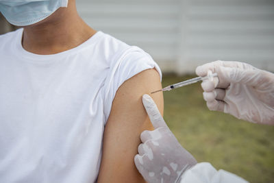 Midsection of man holding thermometer