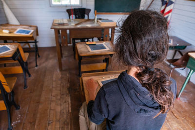 Rear view of woman sitting on table