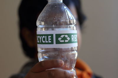 Close-up of person holding plastic bottle