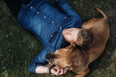 Young man lying down with his dog