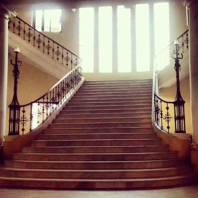 railing, steps and staircases, steps, staircase, architecture, built structure, indoors, metal, stairs, low angle view, the way forward, sunlight, no people, spiral staircase, day, pattern, metallic, building exterior, diminishing perspective, building