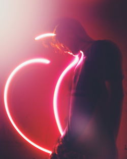 Side view of woman with light painting at night