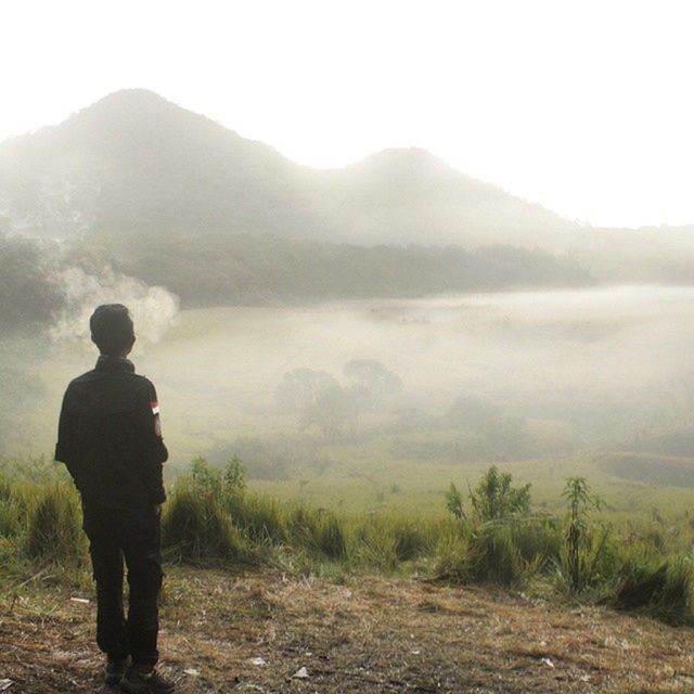 mountain, tranquil scene, tranquility, rear view, landscape, scenics, lifestyles, fog, beauty in nature, leisure activity, mountain range, nature, standing, men, full length, hiking, non-urban scene, foggy