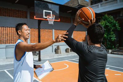 Boy playing with basketball on court