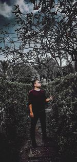 Full length of young man standing against trees in forest