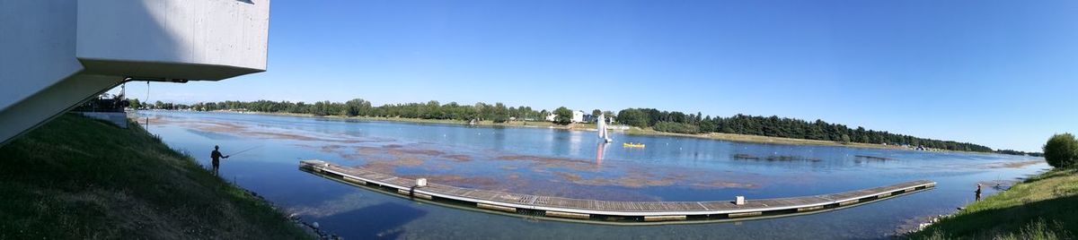 Panoramic view of swimming pool against clear blue sky