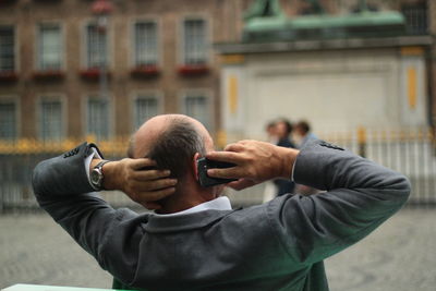 Portrait of man photographing with city in background